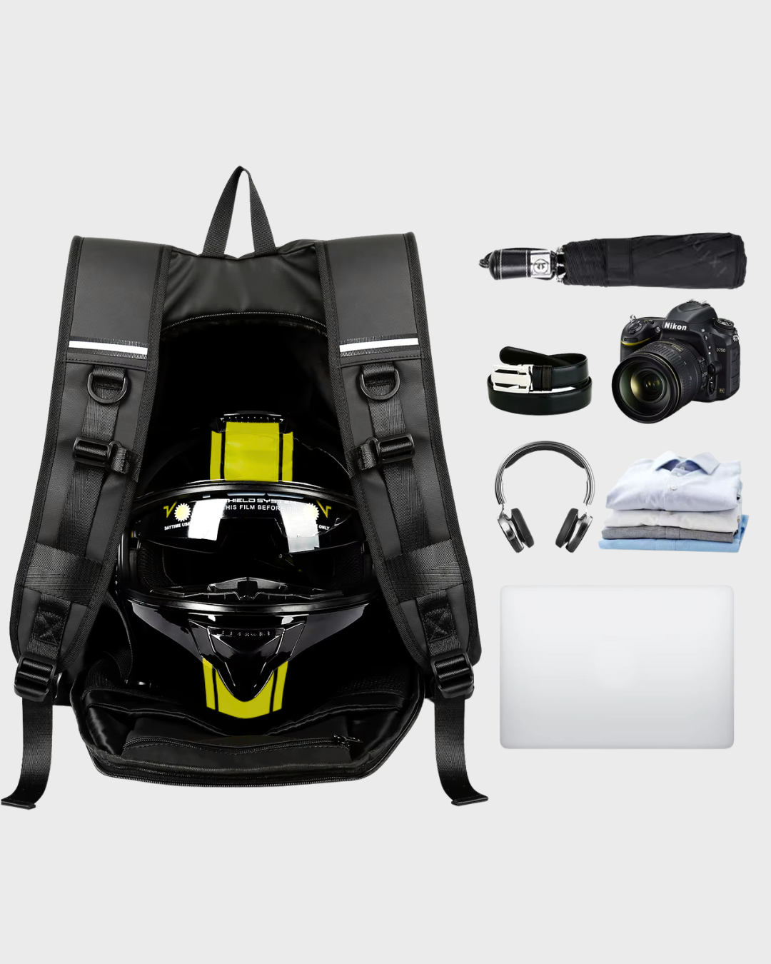 A black waterproof motorcycle backpack shown open with a black and yellow motorcycle helmet inside, alongside accessories arranged on a light gray background: a folded umbrella, a camera, a wristwatch, over-ear headphones, folded clothing, and a laptop.