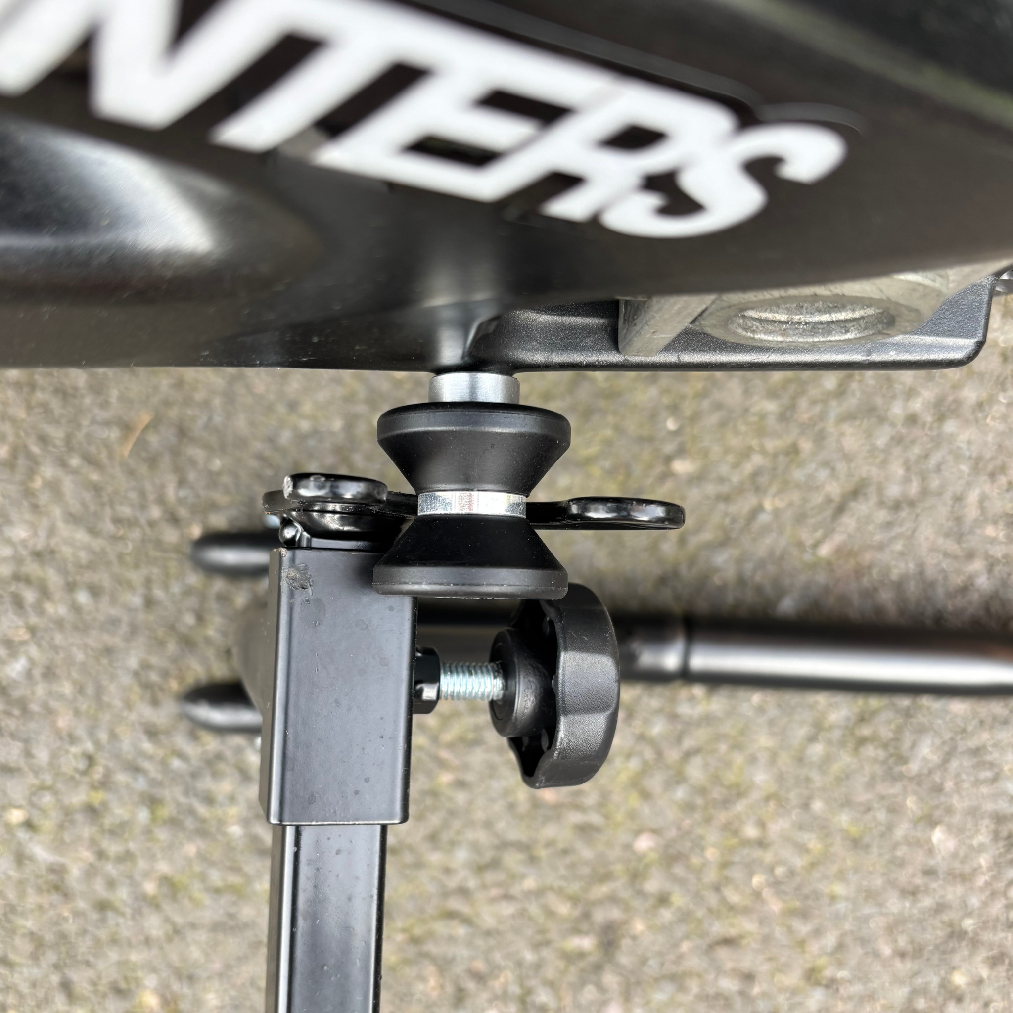 Close up of A Ride It Rite swing-arm spool attached to a motorbike being lifted on a Ride paddock stand.
