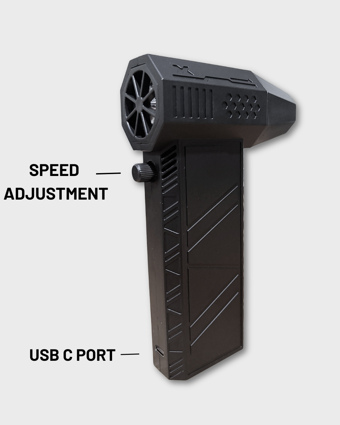 A black handheld motorcycle air blower with a textured grip and a circular fan-like opening at the top, shown on a light gray background with text labels pointing to 'SPEED ADJUSTMENT' and 'USB C PORT'.