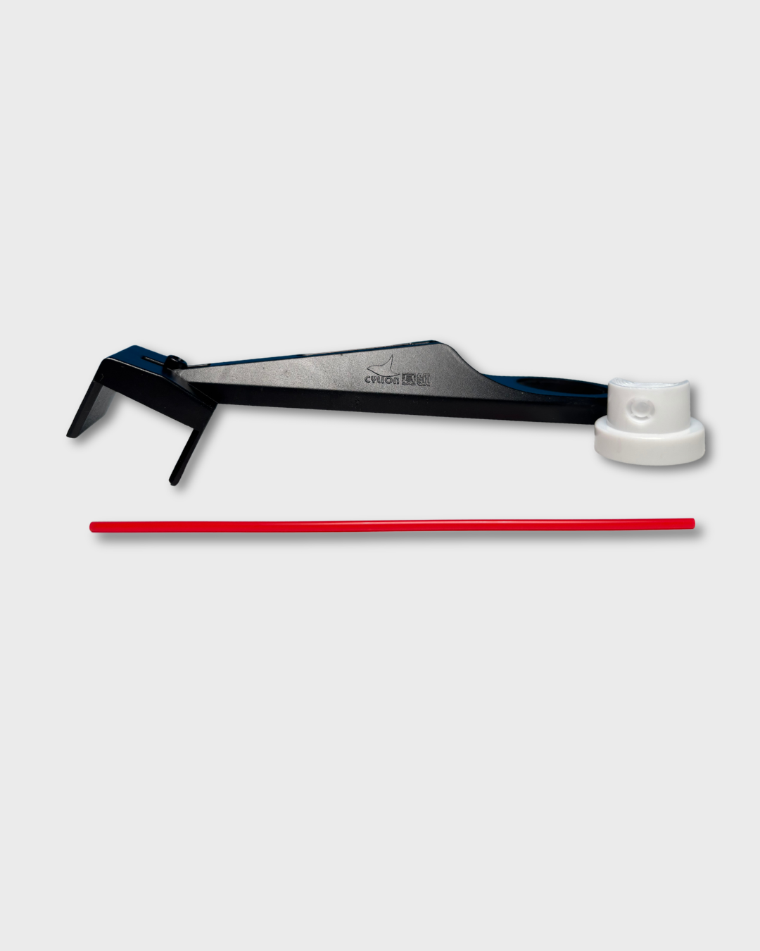 A motorcycle chain oiler tool with a black handle and a white circular end piece, shown on a light gray background with a red rod placed below it.