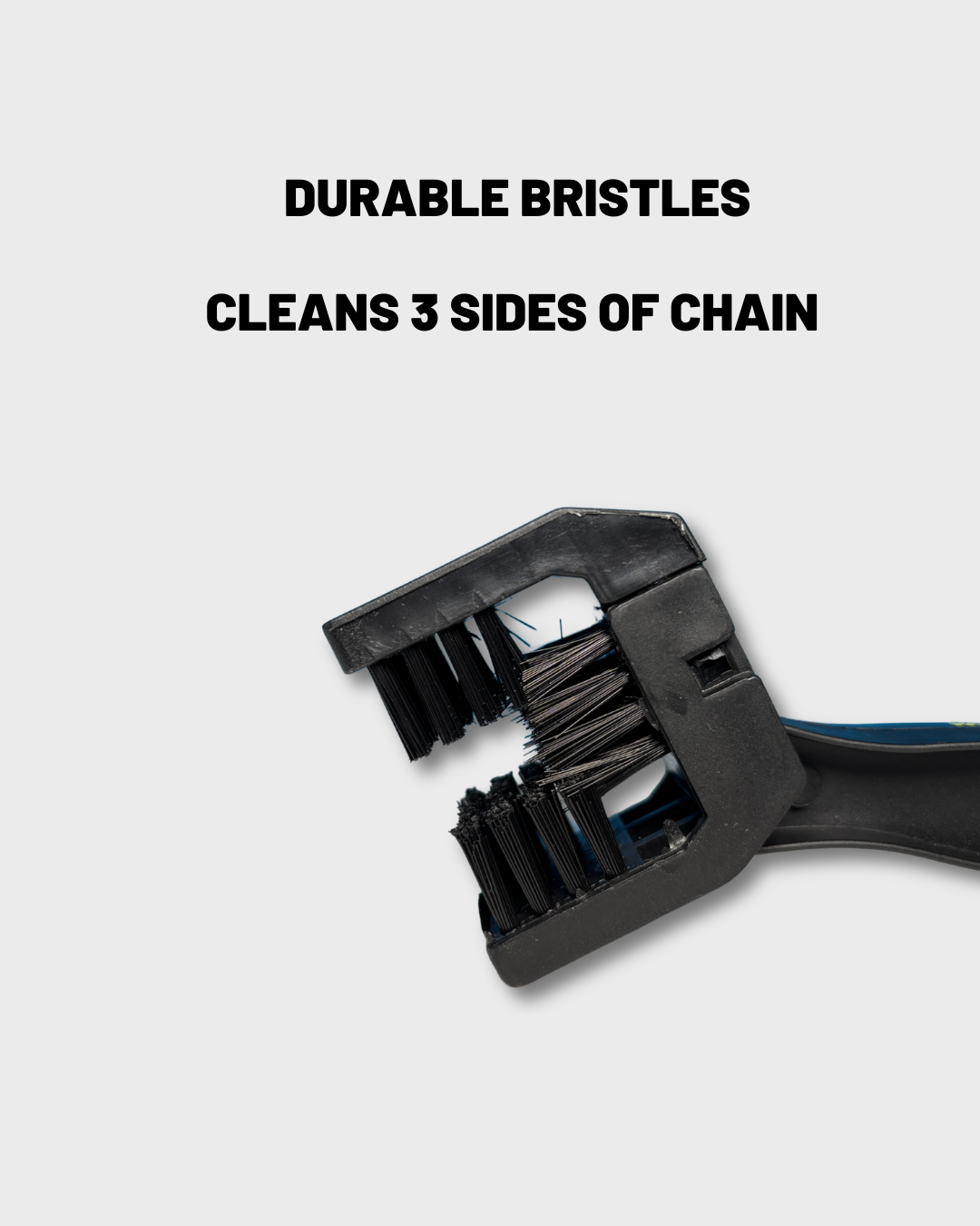 A close-up of a black motorcycle chain cleaning brush head with text above reading 'DURABLE BRISTLES' and 'CLEANS 3 SIDES OF CHAIN' on a light gray background.
