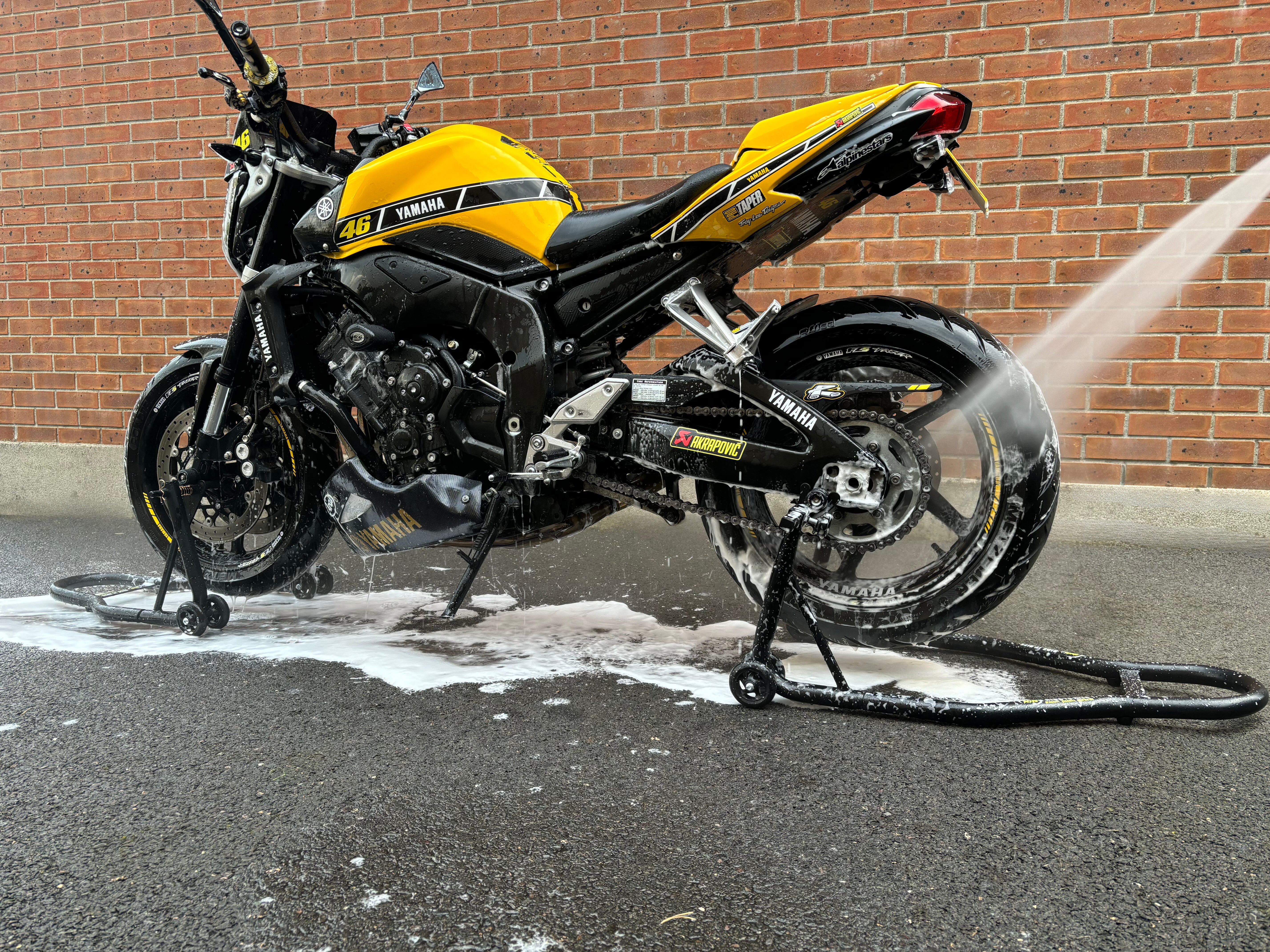 Ride It Rite, paddock stands, motorbike on front and rear paddock stands being rinsed off
