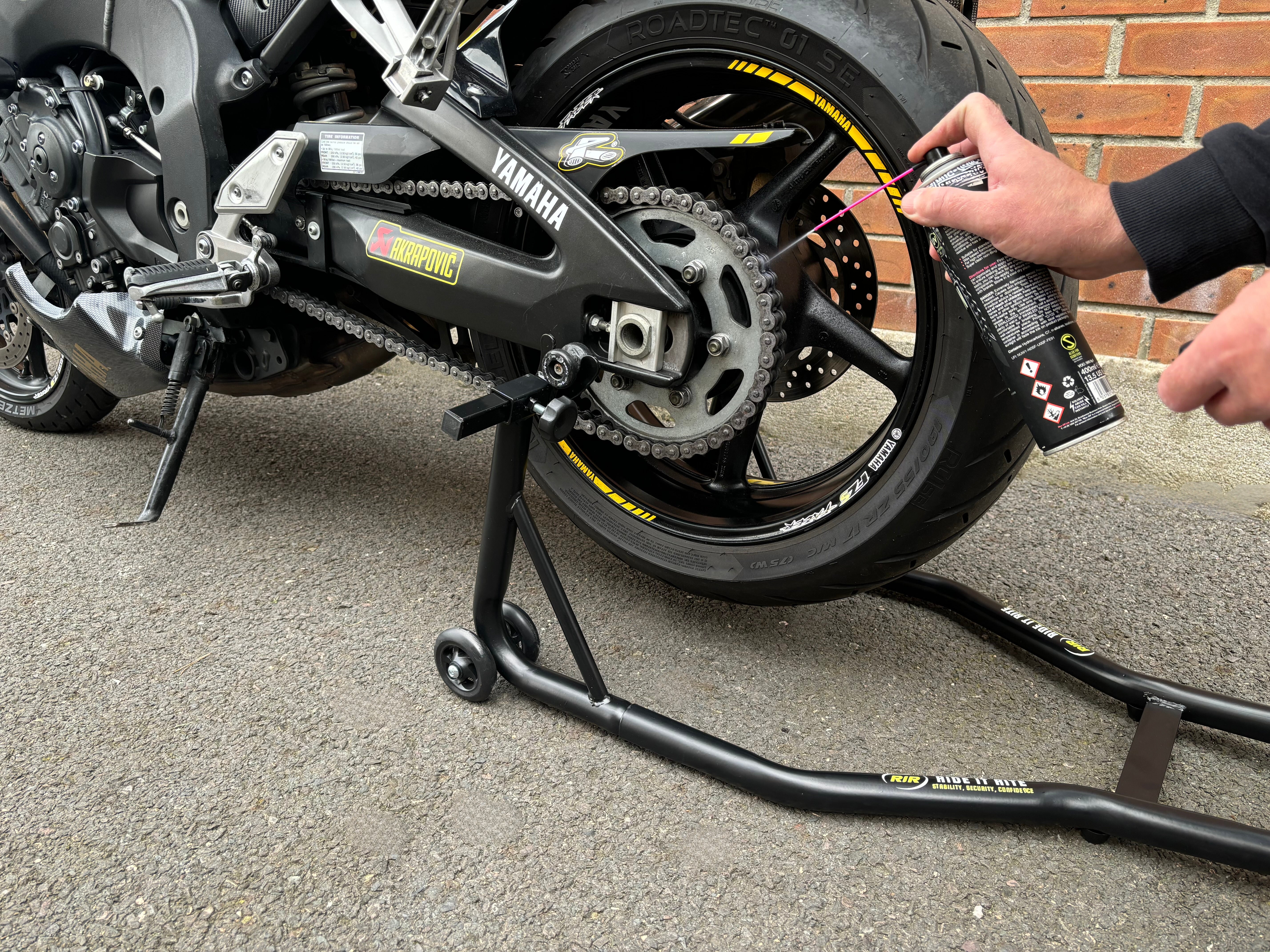 Ride It Rite, paddock stands, motorbike on rear paddock stand chain being oiled
